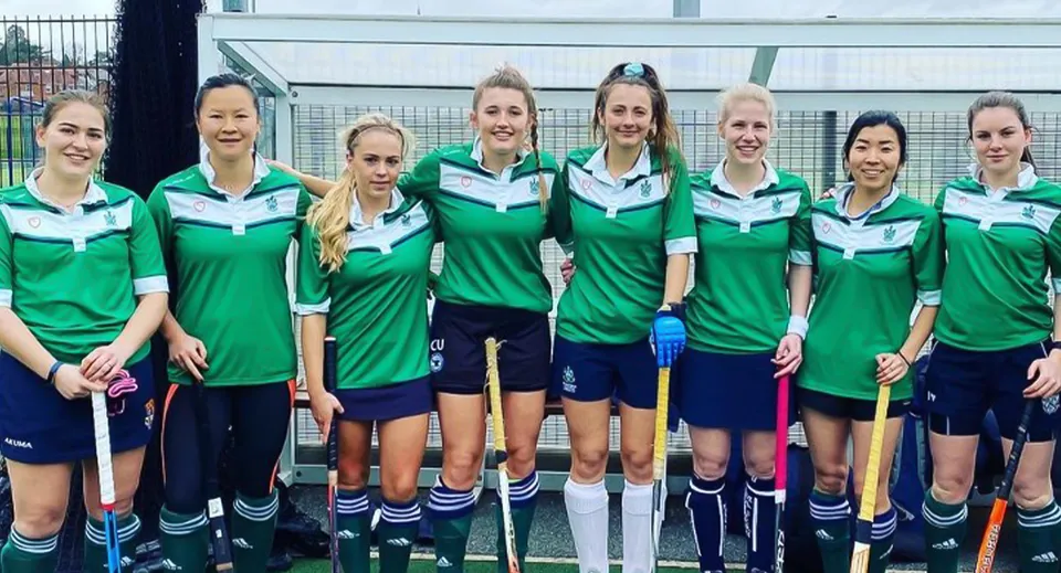 Un gruppo di atlete sta davanti al campo sportivo recintato nel campus del Malvern College.