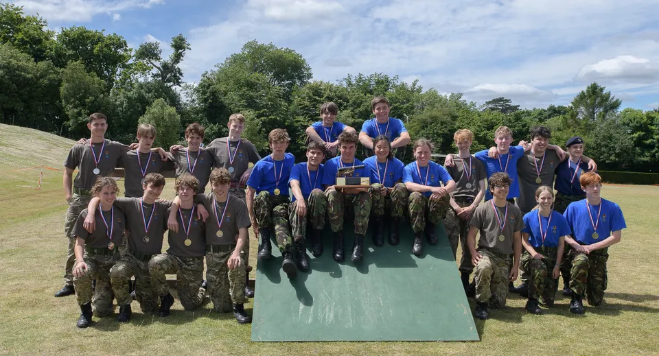 Un gruppo di studenti della Sevenoaks School su un prato con alberi sullo sfondo.