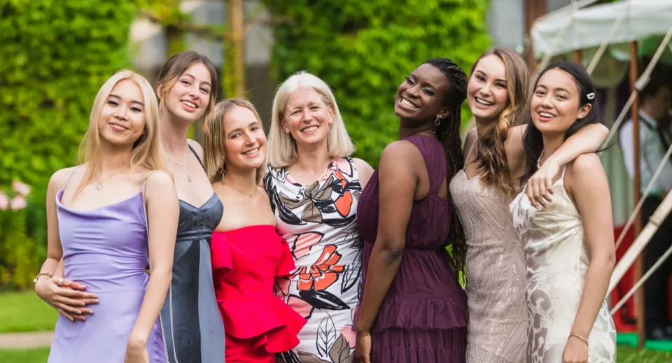 Un gruppo di studentesse vestite in modo elegante posa nell'area verde esterna del Cheltenham Ladies' College.