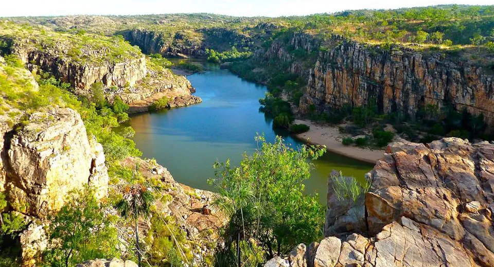 Un canyon roccioso con pareti scoscese e un fiume calmo al centro, circondato dalla vegetazione, vicino alla Sunnybank State High School.