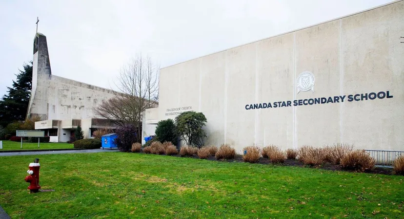 Edificio scolastico moderno della Canada Star Secondary School con un prato ben curato e paesaggio in primo piano.