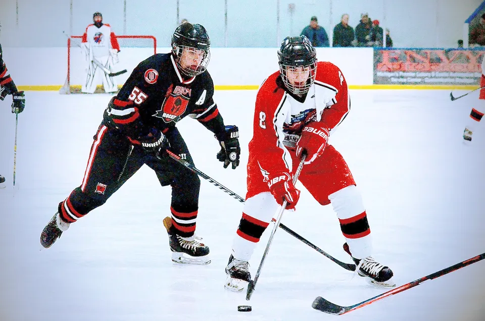 Due giocatori di hockey della Huron High School lottano tra loro durante una partita sul campo di ghiaccio.