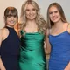 Tre studentesse in abito elegante sorridono insieme durante il loro scambio scolastico