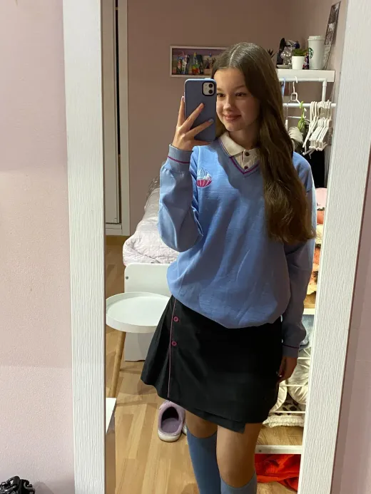 Ragazza in divisa scolastica si fa un selfie allo specchio nella sua camera