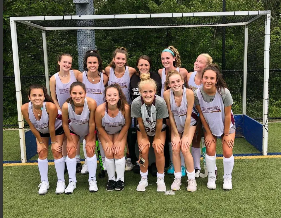 Un gruppo di giovani atlete in piedi sul campo sportivo della Newburyport High School.