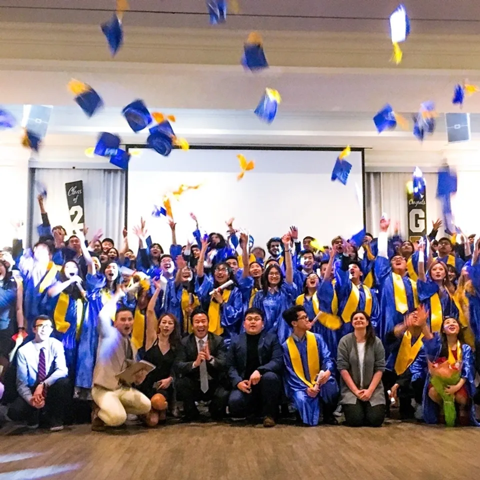 Gli studenti della Urban International High School festeggiano il loro diploma e lanciano i tocchi in aria.