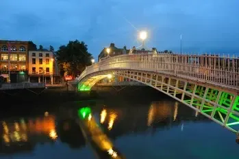 El puente Ha'penny sobre el río Liffey de Dublín iluminado al anochecer