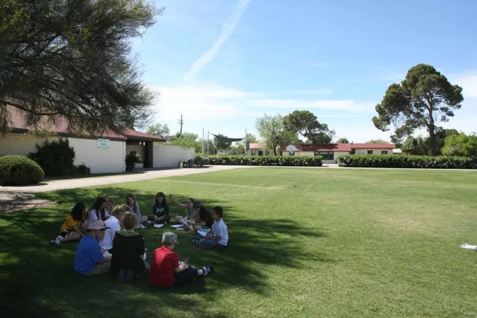 Un gruppo di studenti si trova sul prato erboso all'interno del campus della Green Fields High School.