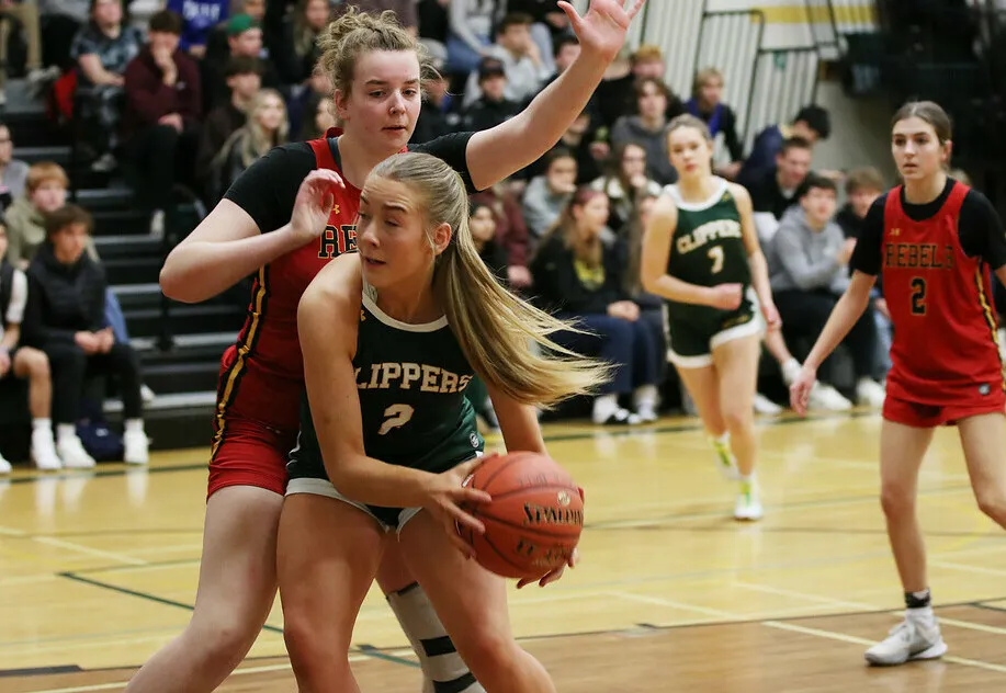 Una jugadora de baloncesto del Lethbridge Collegiate Institute sostiene el balón durante un partido en el gimnasio.