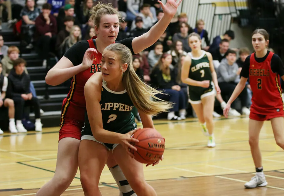 Una giocatrice di pallacanestro del Lethbridge Collegiate Institute tiene la palla durante una partita in palestra.