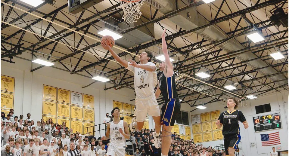 Un giocatore di pallacanestro salta verso il canestro durante una partita nella palestra del Blue Valley School District.