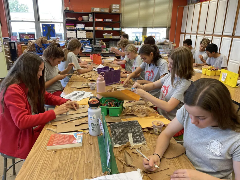 Studenti e studentesse della Sacred Heart Secondary School a Tullamore lavorano a progetti creativi attorno a un tavolo.