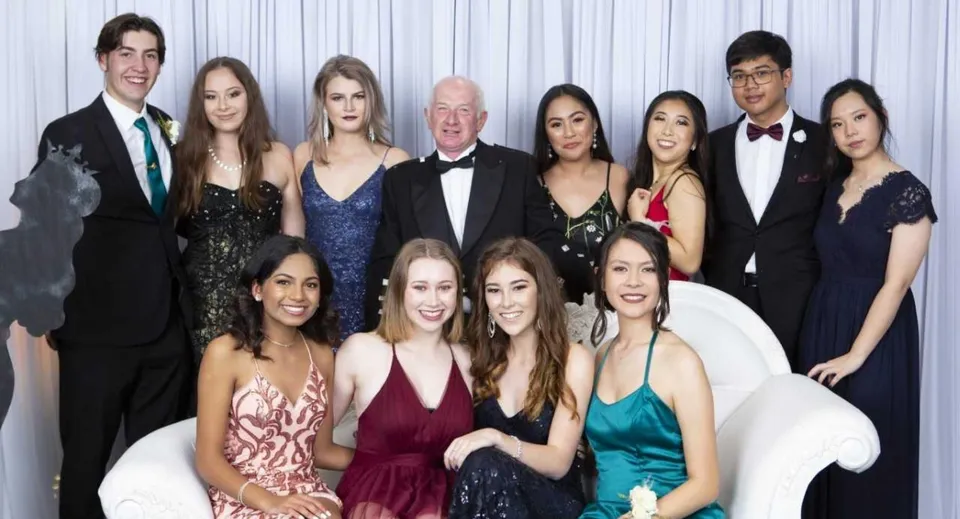 Un gruppo di persone vestite in modo elegante posa per una foto di gruppo formale all'Otumoetai College.