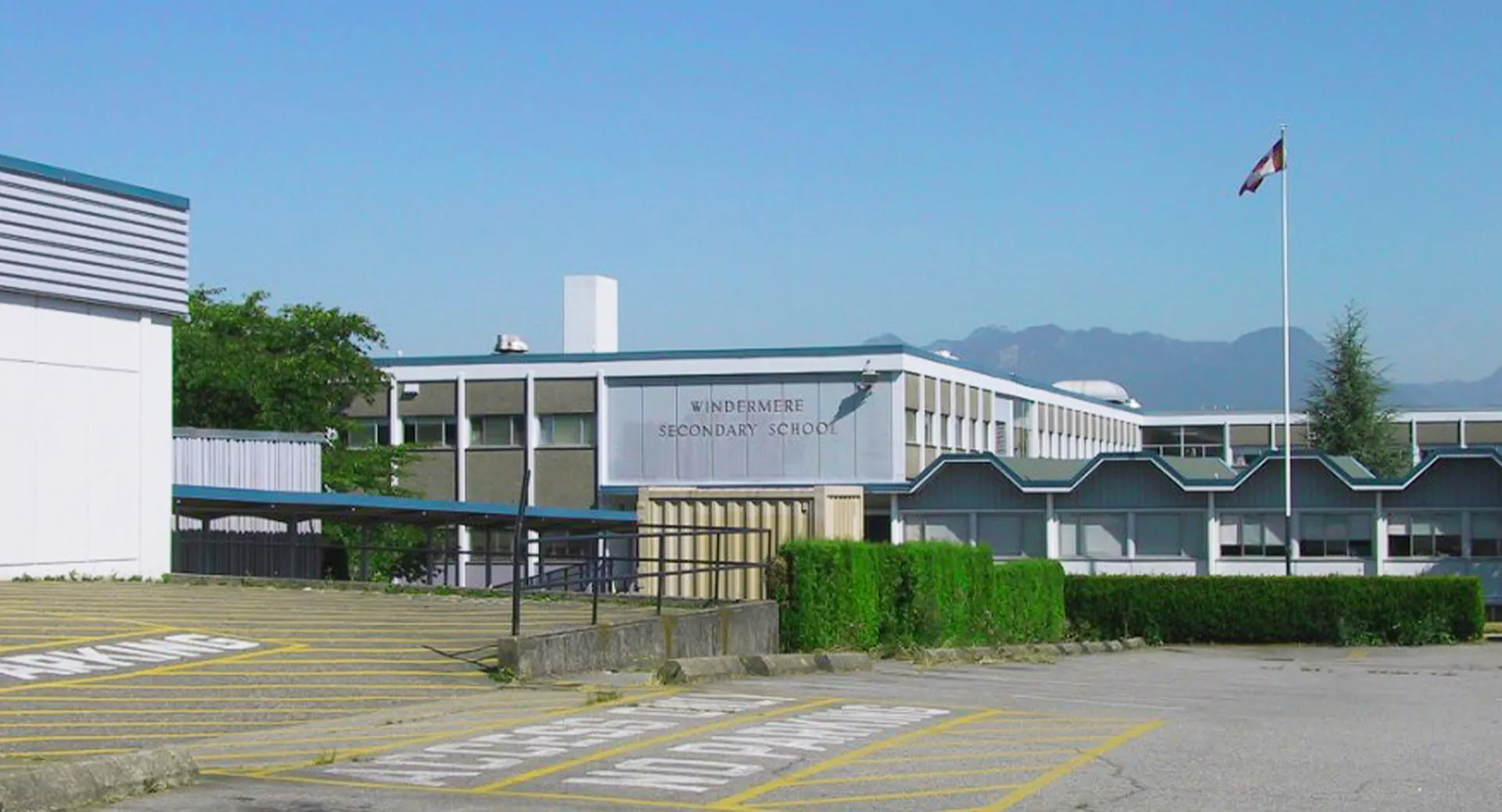 L'edificio moderno a più piani della Windermere Secondary School con una bandiera svizzera che sventola in primo piano.