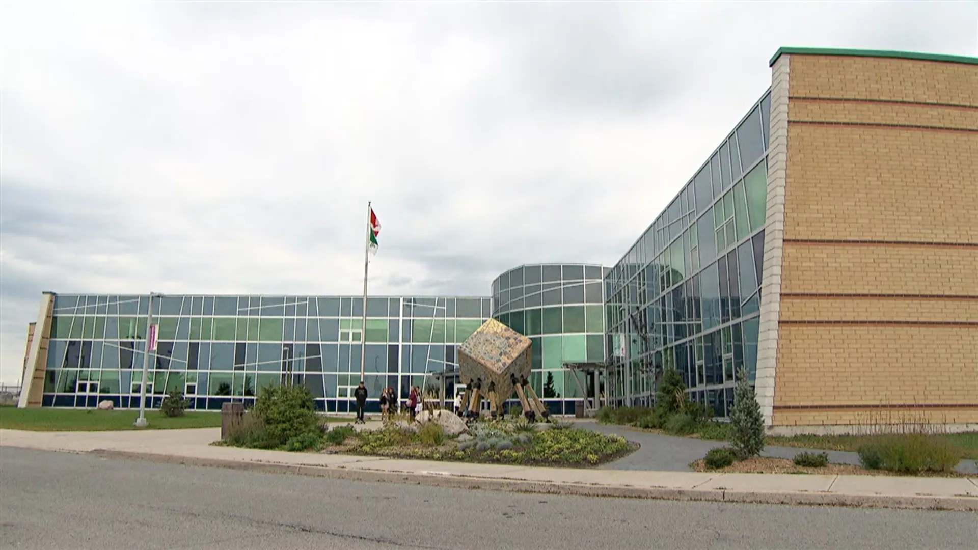L'edificio moderno della École secondaire publique Gisèle-Lalonde con una facciata a vetrate e una scultura davanti all'ingresso.