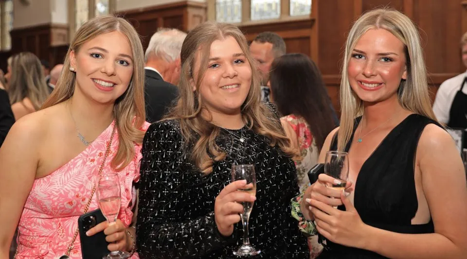 Tre donne sorridenti in abito formale a un evento alla Rydal Penrhos School.