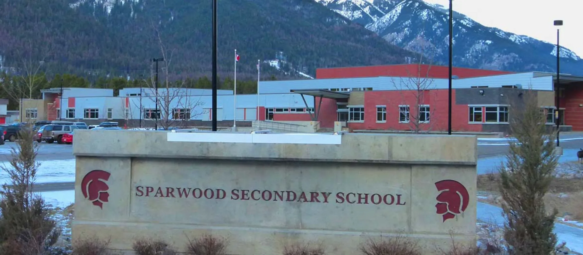 L'edificio scolastico moderno della Sparwood Secondary School con facciata rossa e bianca davanti a montagne innevate.