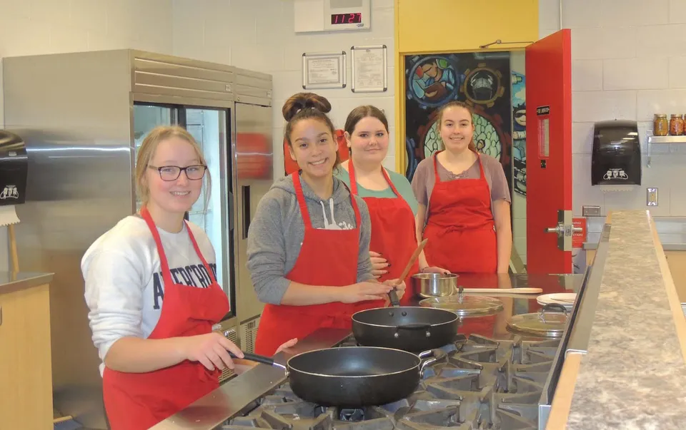Quattro studentesse della Hammarskjold High School sono in cucina e preparano da mangiare insieme.