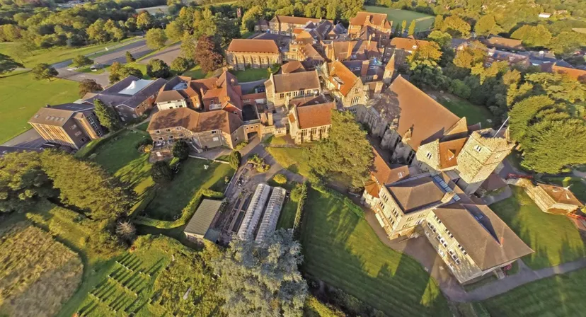 Vista aerea di un castello medievale con tetti rossi e torri sul terreno della Mayfield School.