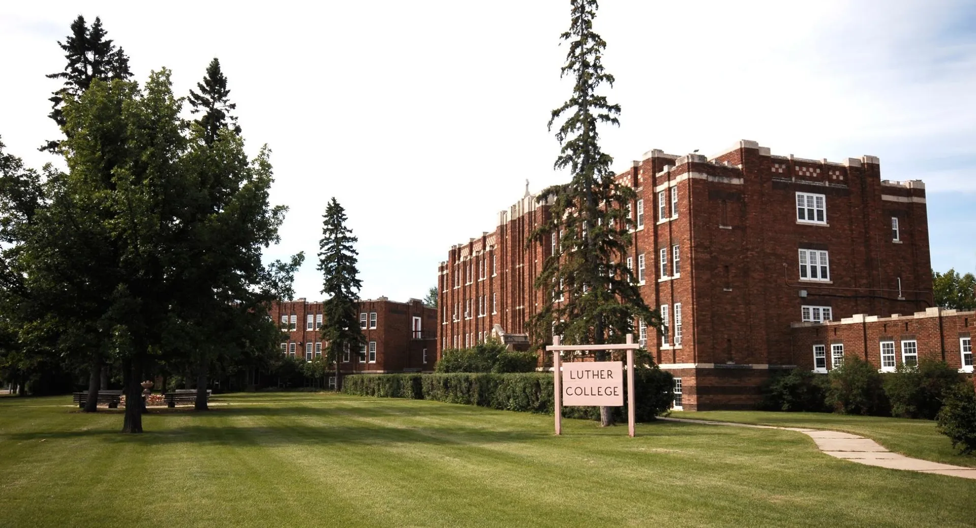 L'edificio in mattoni della Luther College High School sorge su un'area verde circondata da alberi.