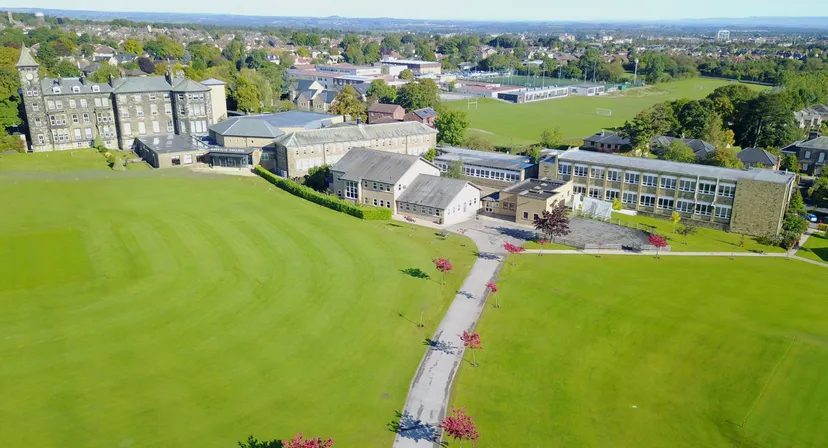 Il campus dell'Ashville College è immerso in un lussureggiante verde, con un viale sinuoso tra edifici storici e moderni.