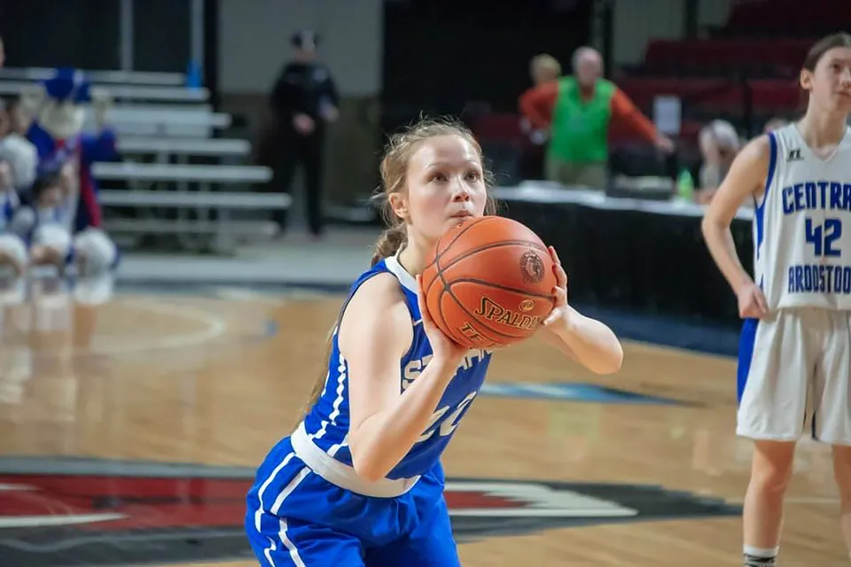 Una giovane giocatrice di basket della Stearns High School che palleggia sul campo da basket.