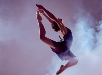 Una bailarina de la Ottawa Sports Academy Private School realiza un salto en el aire entre humo.