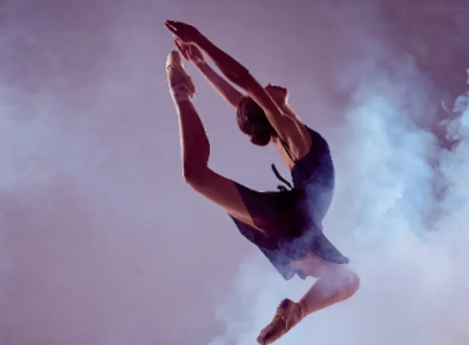 Una ballerina della Ottawa Sports Academy Private School esegue un salto in aria circondata dal fumo.