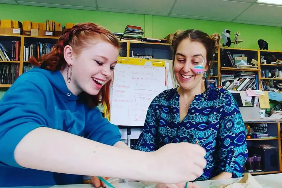 Una studentessa della Montpelier High School dipinge il viso di una donna in un'aula.