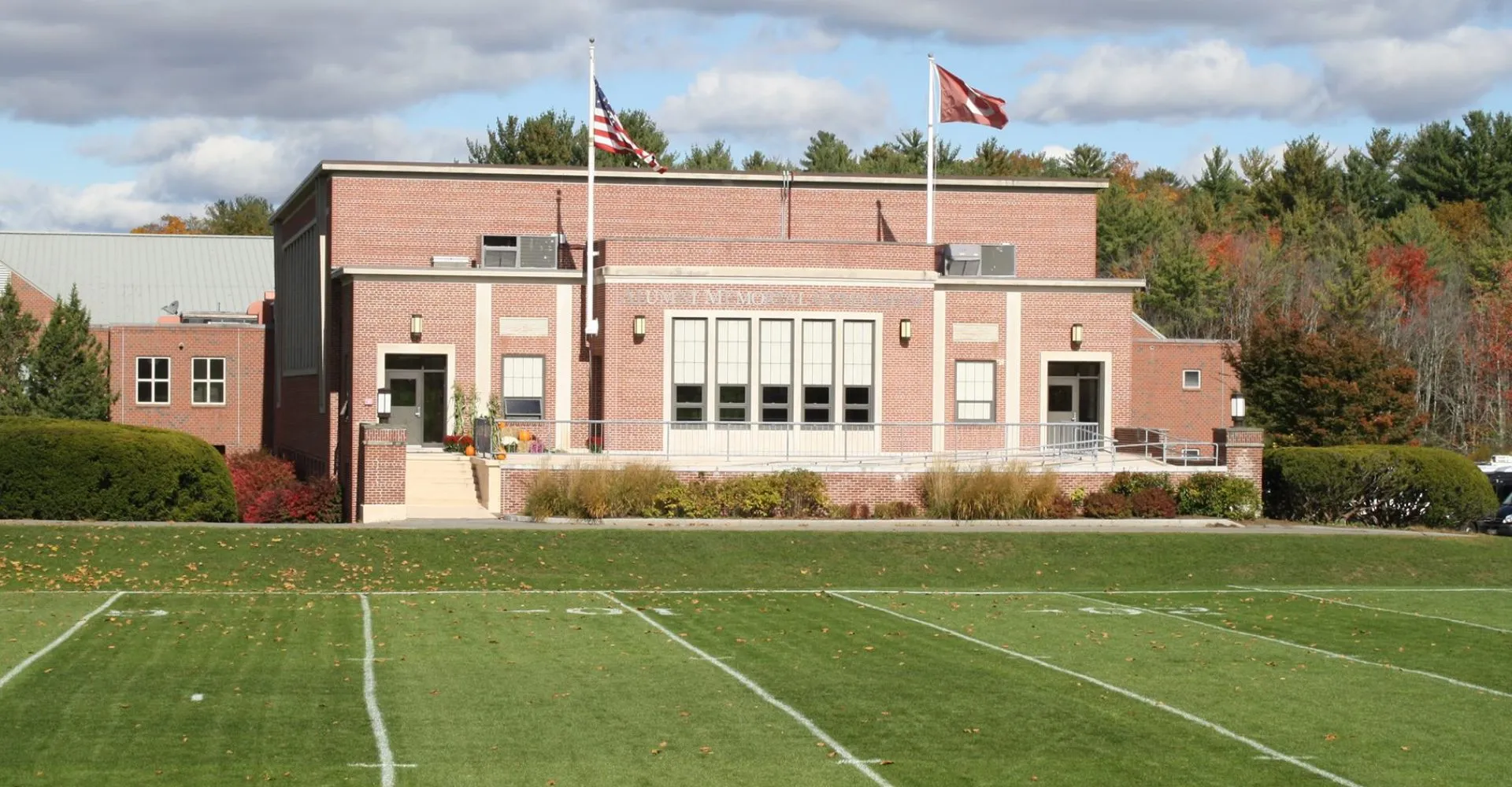 L'edificio in mattoni della The Governor's Academy con grandi finestre e la bandiera americana sullo sfondo dietro un campo da gioco.
