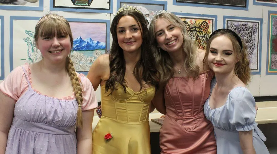Quattro studentesse della North Halifax Grammar School stanno davanti a una parete con varie opere d'arte incorniciate.