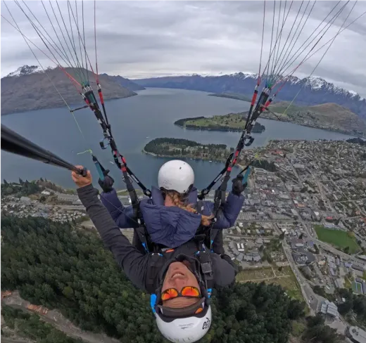 Tandem-Gleitschirmflug über einen See und die Berge Neuseelands