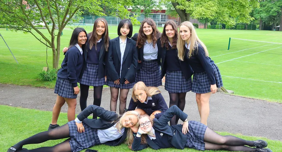 Un gruppo di studentesse della The Mount School York su un prato davanti ad alcuni alberi.