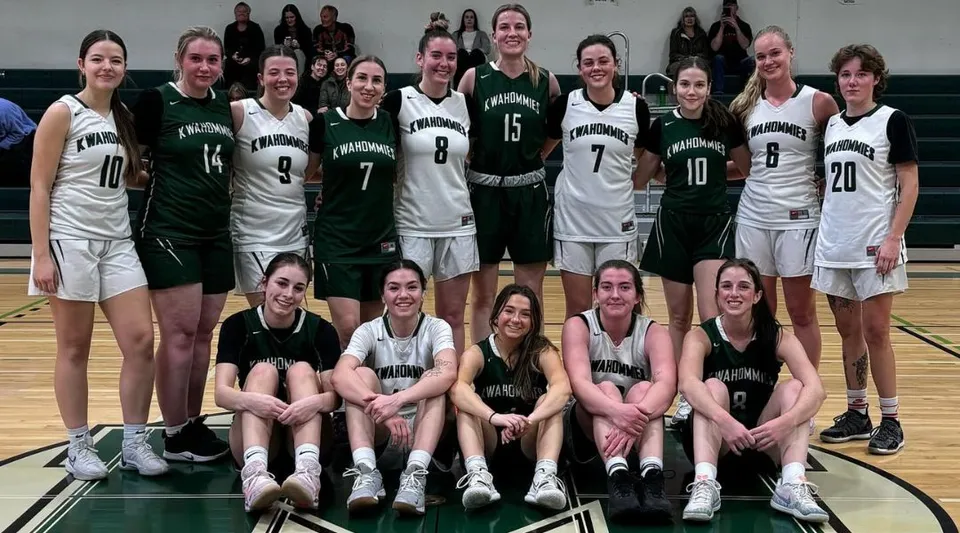 Un gruppo di studentesse della Medicine Hat High School posa insieme sul campo da basket.