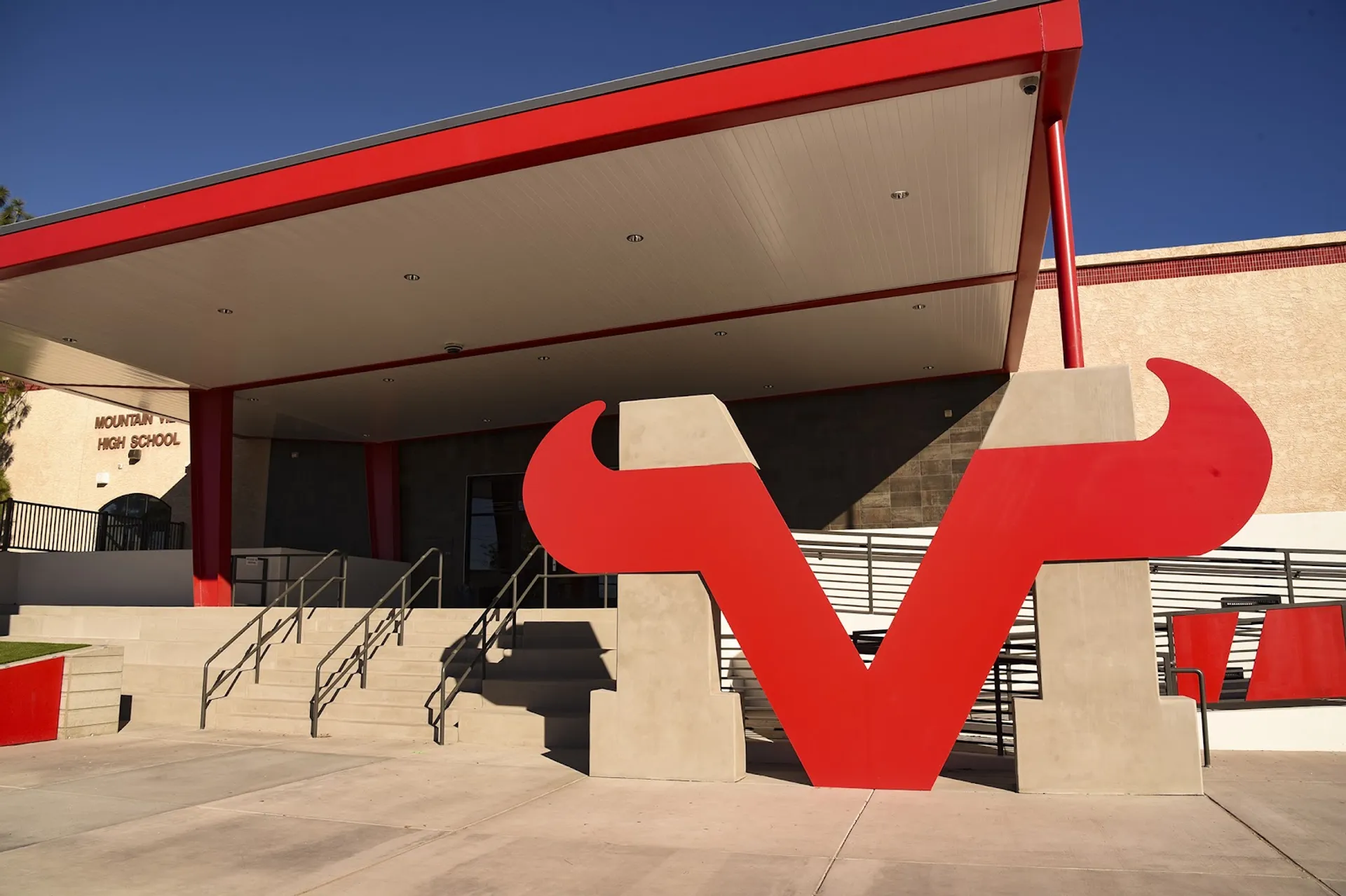 L'edificio moderno della Mountain View High School con grandi sculture astratte rosse in primo piano davanti a un cielo blu.