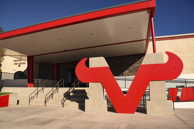 Das moderne Gebäude der Mountain View High School mit großen roten abstrakten Skulpturen im Vordergrund vor blauem Himmel.