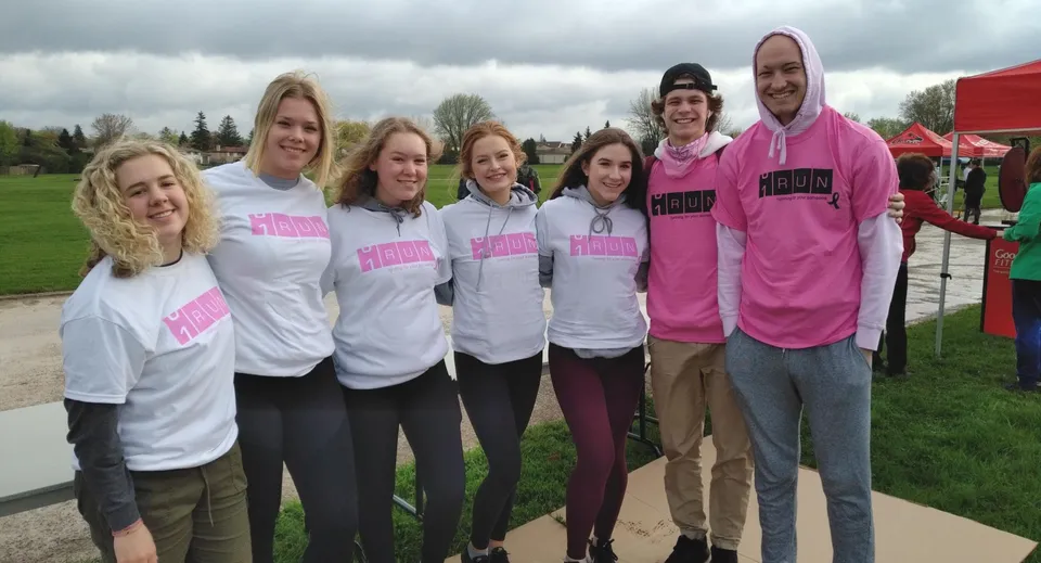 Un gruppo di studenti e studentesse della Sir Wilfrid Laurier Secondary School è in piedi su un prato davanti agli edifici.
