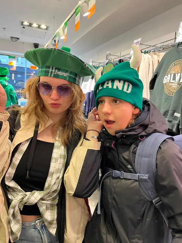 Dos chicas probándose gorros verdes de Irlanda en una tienda de recuerdos