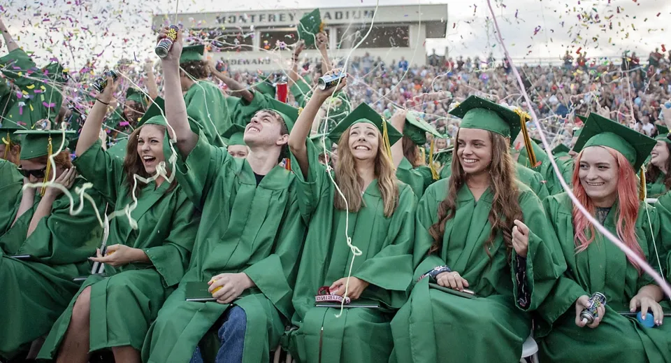 I neodiplomati della St. Patrick's High School festeggiano in toga verde tra i coriandoli.
