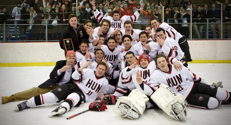 Un gruppo di giocatori di hockey in posa per una foto di squadra sulla pista da ghiaccio della The Hun School of Princeton.