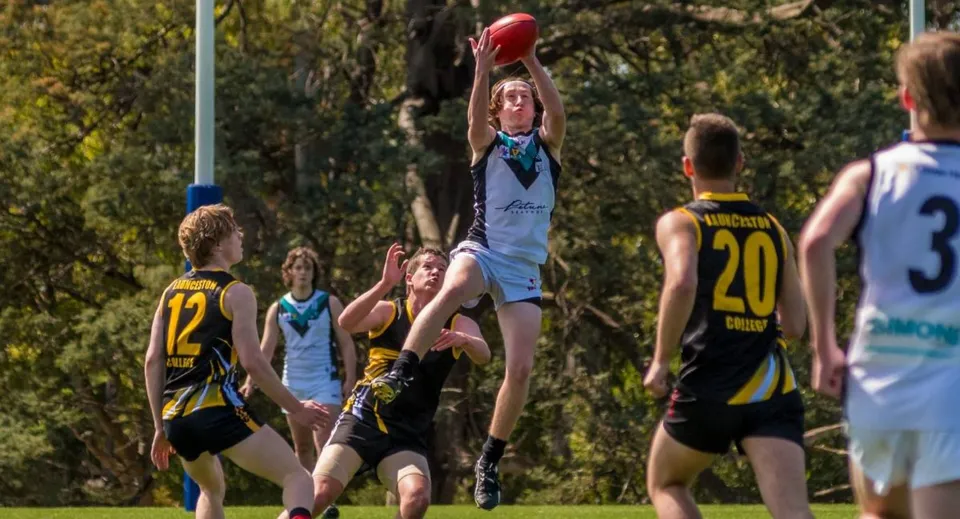 Studenti del Launceston College giocano all'aperto e un giocatore cerca di afferrare la palla.