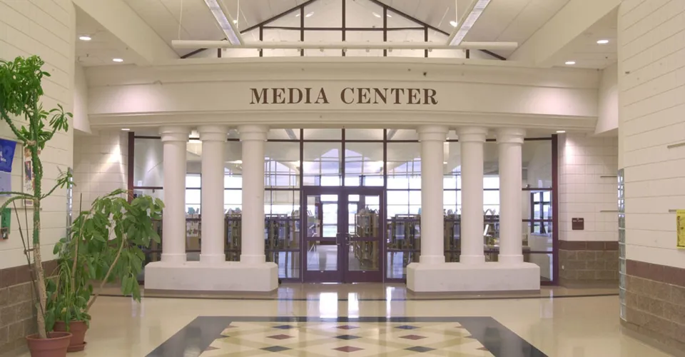 Il Media Center della American Falls High School mostra un'ampia area d'ingresso con alti soffitti e colonne.