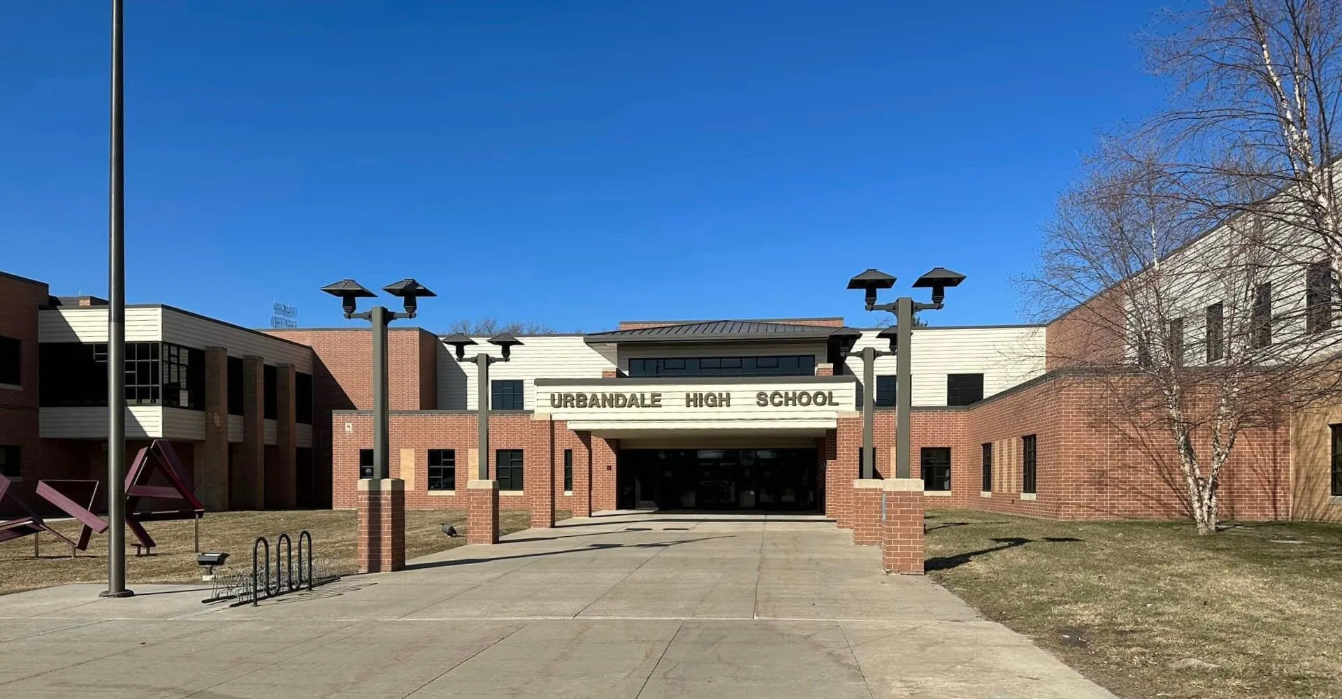 L'edificio in mattoni del Urbandale Community School District è circondato da un sentiero pavimentato e lampioni stradali.