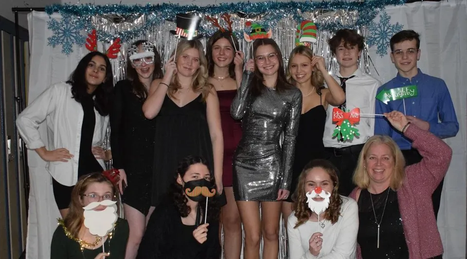Un gruppo di studenti e studentesse del Perth & District Collegiate Institute posa davanti a decorazioni festive.