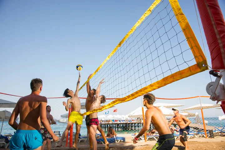 Schüler spielen Beachvolleyball am Strand