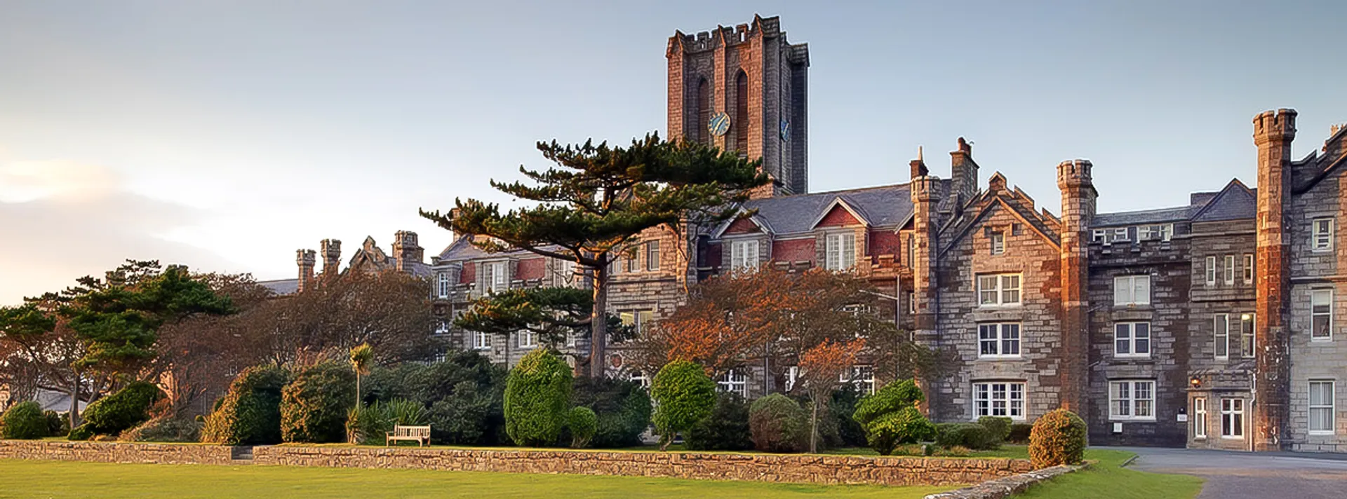 Il King William's College mostra un edificio simile a un castello con alte torri e un'architettura decorata sotto un cielo limpido.