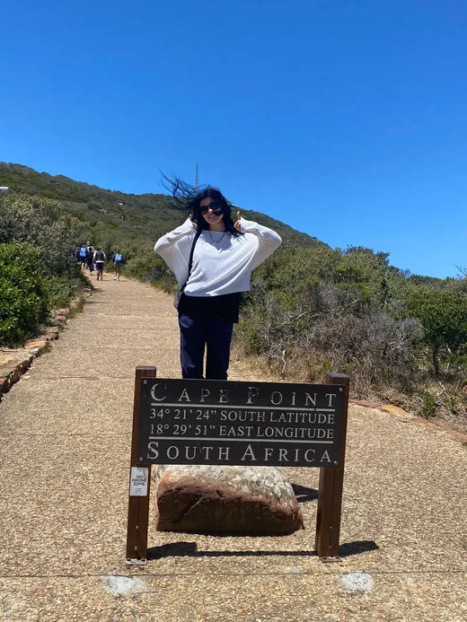 Studentessa accanto al cartello di Cape Point in Sudafrica