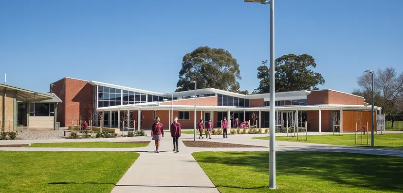 L'edificio moderno della Underdale High School è circondato da un prato e alberi, davanti all'ingresso principale diverse persone camminano su un sentiero.