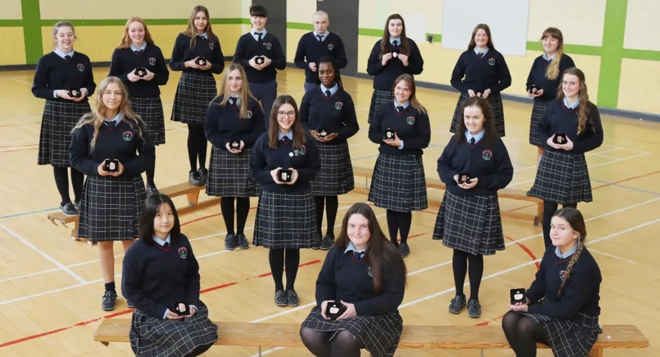Un gruppo di studenti e studentesse del Presentation College Carlow in divisa scolastica all'interno della palestra.