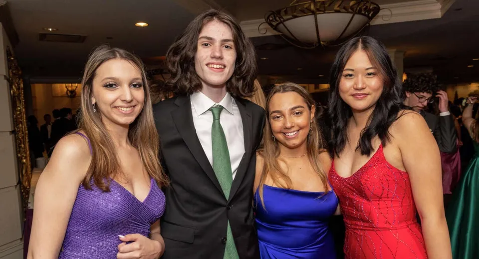 Quattro studenti e studentesse della Stamford High School sono insieme a un evento formale in abiti eleganti.